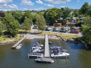 A lakeside view with boats docked at piers near holiday cabins at Loubi's Lakeside Lodge M1 Fallbarrow Park near Bowness-On-Windermere
