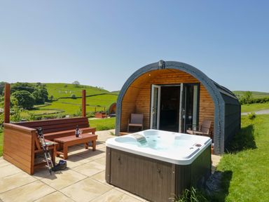 An outdoor area with a hot tub and wooden seating at Beech in Ulverston