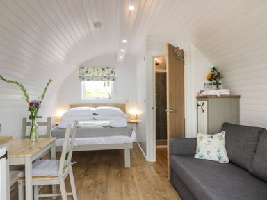 A bedroom with a bed dining table chairs and a sofa at Laird Lodge 3 in Lochmaben