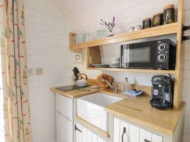 A small kitchen with wooden countertops microwave coffee machine and sink at Laird Lodge 4 in Lochmaben