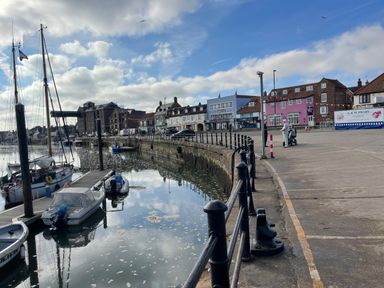 A harbor with boats docked near a quay and buildings along the waterfront at Jolly Sailors Retreat - Wells next the Sea in Wells-Next-The-Sea