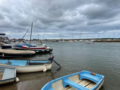 A harbor with several boats on water under a cloudy sky at Jolly Sailors Retreat - Wells next the Sea in Wells-Next-The-Sea