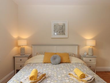 A bedroom with a double bed and two bedside tables with lamps at Mimosa in Dawlish