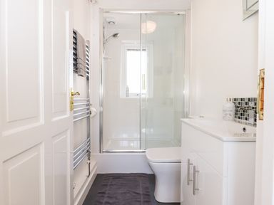 A bathroom with a shower enclosure toilet sink cabinet and towel rack at Little Rowan at Rowan Park Farm in Ashwater