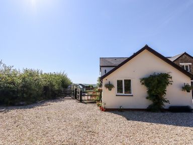 A house with a gravel driveway and a garden gate at Little Rowan at Rowan Park Farm in Ashwater