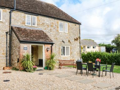 A house with a patio area and seating at The Abbey Grange near Charmouth
