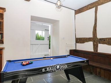 A game room with a pool table and door at The Abbey Grange near Charmouth