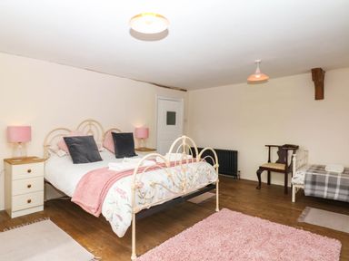 A bedroom with a bed and side table at The Abbey Grange near Charmouth