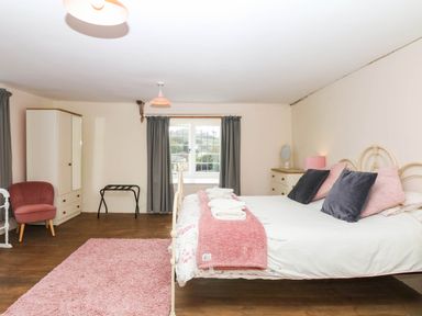 A bedroom with a bed and wardrobe at The Abbey Grange near Charmouth
