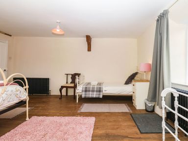 A bedroom with two beds and a chair at The Abbey Grange near Charmouth