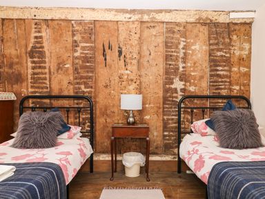 A bedroom with two beds and a lamp on a side table at The Abbey Grange near Charmouth