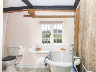 A bathroom with a bathtub and toilet at The Abbey Grange near Charmouth
