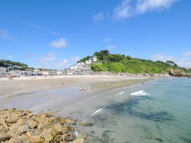 A beach with water and people near buildings at The Abbey Grange near Charmouth
