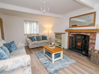 A living room with two sofas and a coffee table in front of a fireplace at 2 Penporth in Rhayader