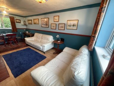 A living room with sofas and a dining area at 11 Penygroes in Llanddeusant