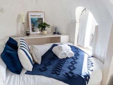 A bedroom with a neatly made bed blue and white pillows and rolled towels on a bed cover at Andrus - Mayflower Meadow in Brandesburton