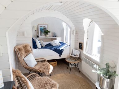 A small bedroom with a bed towels wicker chairs and a round rug at Andrus - Mayflower Meadow in Brandesburton