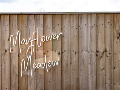 A wooden fence with a sign reading Mayflower Meadow at Andrus - Mayflower Meadow in Brandesburton