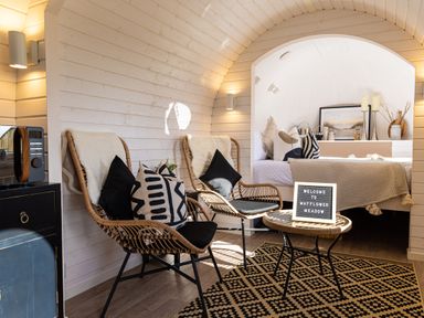 A seating area with two wicker chairs and a table with a welcome sign next to a bedroom at Indrek - Mayflower Meadow in Brandesburton