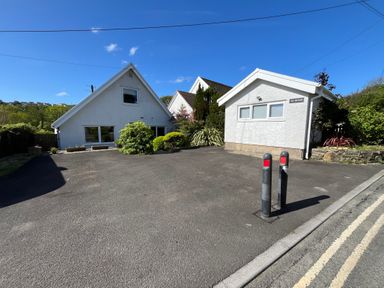 A paved driveway with two houses and greenery at Old Orchard in Saundersfoot