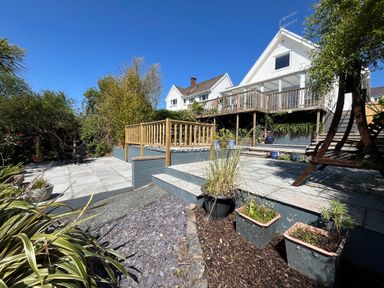 A multi level garden with patio areas plants and wooden railing at Old Orchard in Saundersfoot