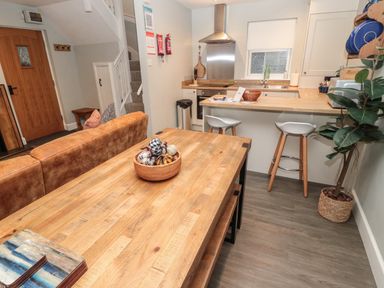 A kitchen and dining area with wooden table and stools at Dodds Nook in Alnwick