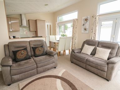 A living room with two sofas and a dining table with chairs at Waterside Lodge South Lakeland Leisure Village near Carnforth