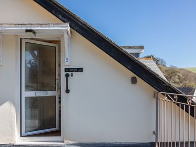 The entrance door of a house with the number 5 and name Goody on the wall at Goody in Hope Cove