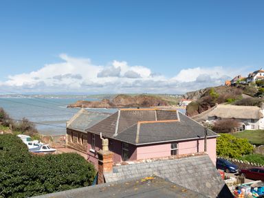 Houses near a coastline with rocky cliffs and the sea in the background at Goody in Hope Cove
