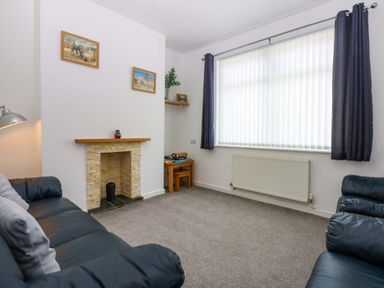 A living room with a sofa and fireplace at Y Berth in Caernarfon