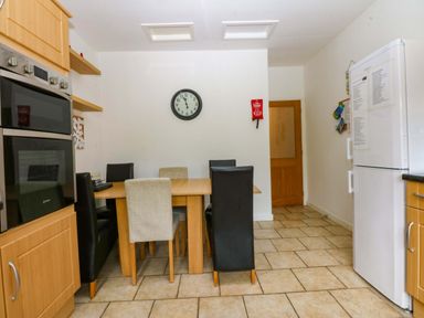 A kitchen with a table and chairs at Y Berth in Caernarfon