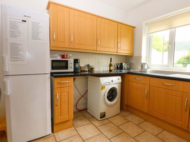 A kitchen with a washing machine and refrigerator at Y Berth Caernarfon