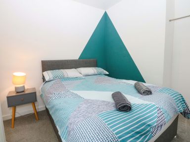 A bedroom with a bed and nightstand at Y Berth in Caernarfon
