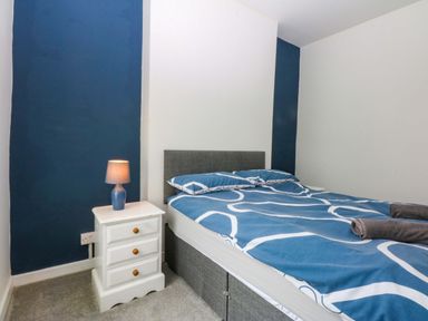 A bedroom with a bed and a bedside table at Y Berth in Caernarfon