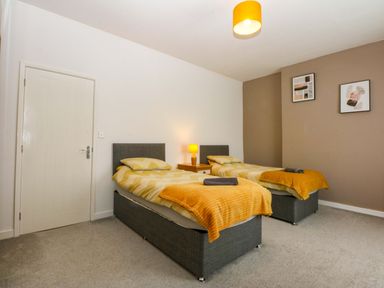 A bedroom with twin beds and a lamp at Y Berth in Caernarfon
