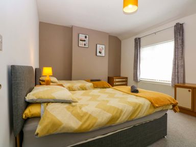 A bedroom with two beds and a lamp at Y Berth in Caernarfon