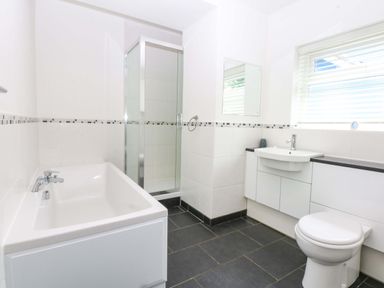 A bathroom with a bathtub, shower, sink, and toilet at Y Berth Caernarfon