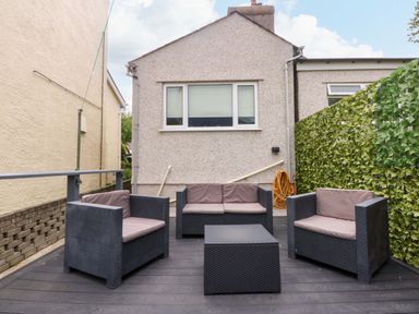 A garden with seating area and coffee table at Y Berth in Caernarfon