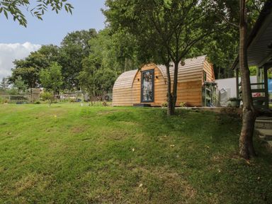 A wooden pod room near trees and grass at The Pod in Worthen near Minsterley