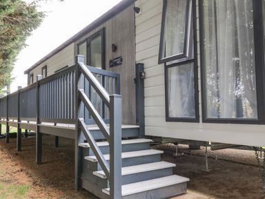 The exterior of a lodge with steps and a railing leading to the entrance at Finch 59 in Cayton