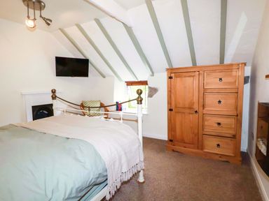 A bedroom with a bed and wardrobe at Woodview in Looe