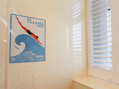 A wall poster with a diver and window shutters in a room at Maypole Cottage in Fylingthorpe