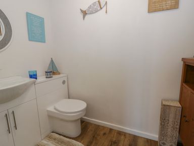 A bathroom with a sink and toilet at Swallows Retreat in Tenby