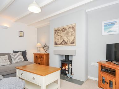 A living room with a fireplace a sofa a coffee table and a television at Quay House in Charlestown