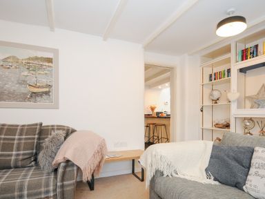 A living room with two sofas a wooden table a painting and a bookshelf at Quay House in Charlestown