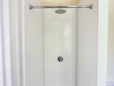A shower stall with a rainfall showerhead and control handle in a bathroom at Nethercott House in Iddesleigh near Hatherleigh