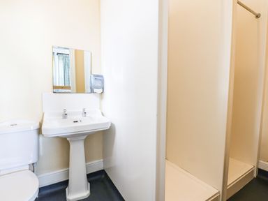 A bathroom with a toilet sink mirror and two shower stalls at Nethercott House in Iddesleigh near Hatherleigh