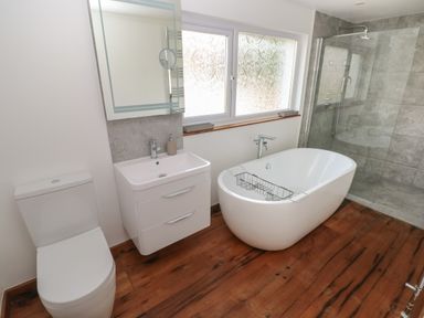 A bathroom with a toilet sink bathtub and a glass shower at Sandtop in Tenby
