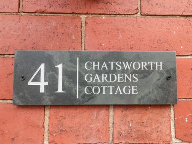A house number plaque reading 41 Chatsworth Gardens Cottage on a brick wall at 41 Chatsworth Gardens in Scarborough