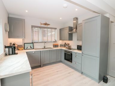 A kitchen with gray cabinets white countertops a built in oven and microwave and a window with blinds at 41 Chatsworth Gardens Scarborough